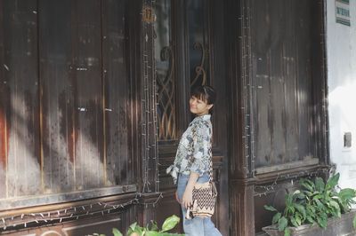 Young woman standing against wall