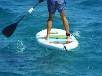 Low section of man paddleboarding