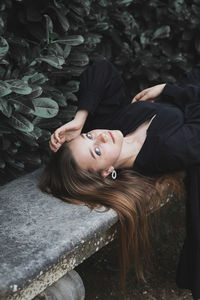 Portrait of woman lying on land by plants