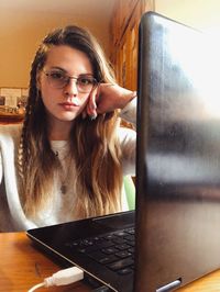 Portrait of young woman using mobile phone at home