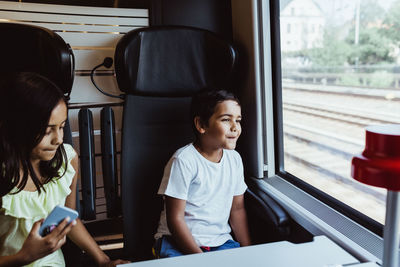 Full length of boy sitting in bus