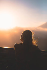 Rear view of woman looking at sunset