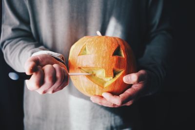 Midsection of man holding pumpkin