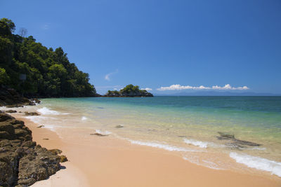 Scenic view of beach against blue sky