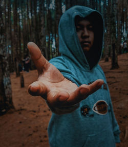 Midsection of man standing by tree trunk