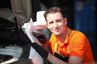 Portrait of smiling young man holding car