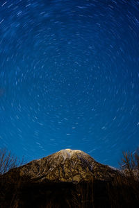 Low angle view of star trails at night