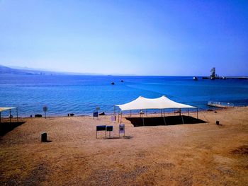 Scenic view of beach against clear blue sky
