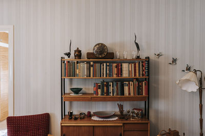 Books and antiques arranged in shelf at home