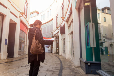 Man standing on street amidst buildings