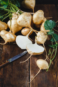 High angle view of fresh jicamas with knife on table