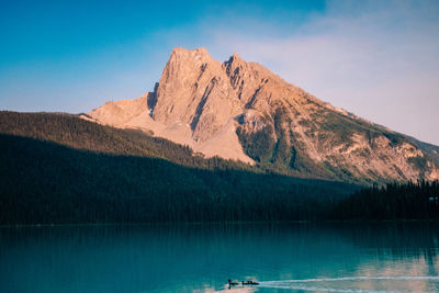 Scenic view of lake and mountains against blue sky