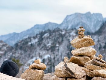 Stack of stones on rock against sky