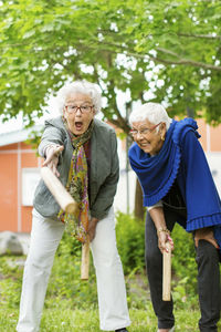 Excited senior people enjoying kubb game at park