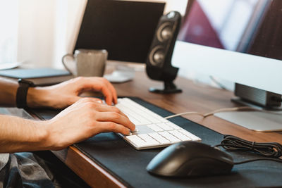 Close-up of man using laptop on table