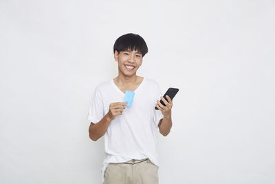 Portrait of smiling man standing against white background