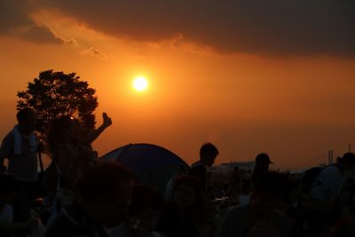 Silhouette people against sky during sunset