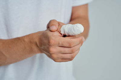 Close-up of man holding hands over white background