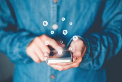 Midsection of man using mobile phone
