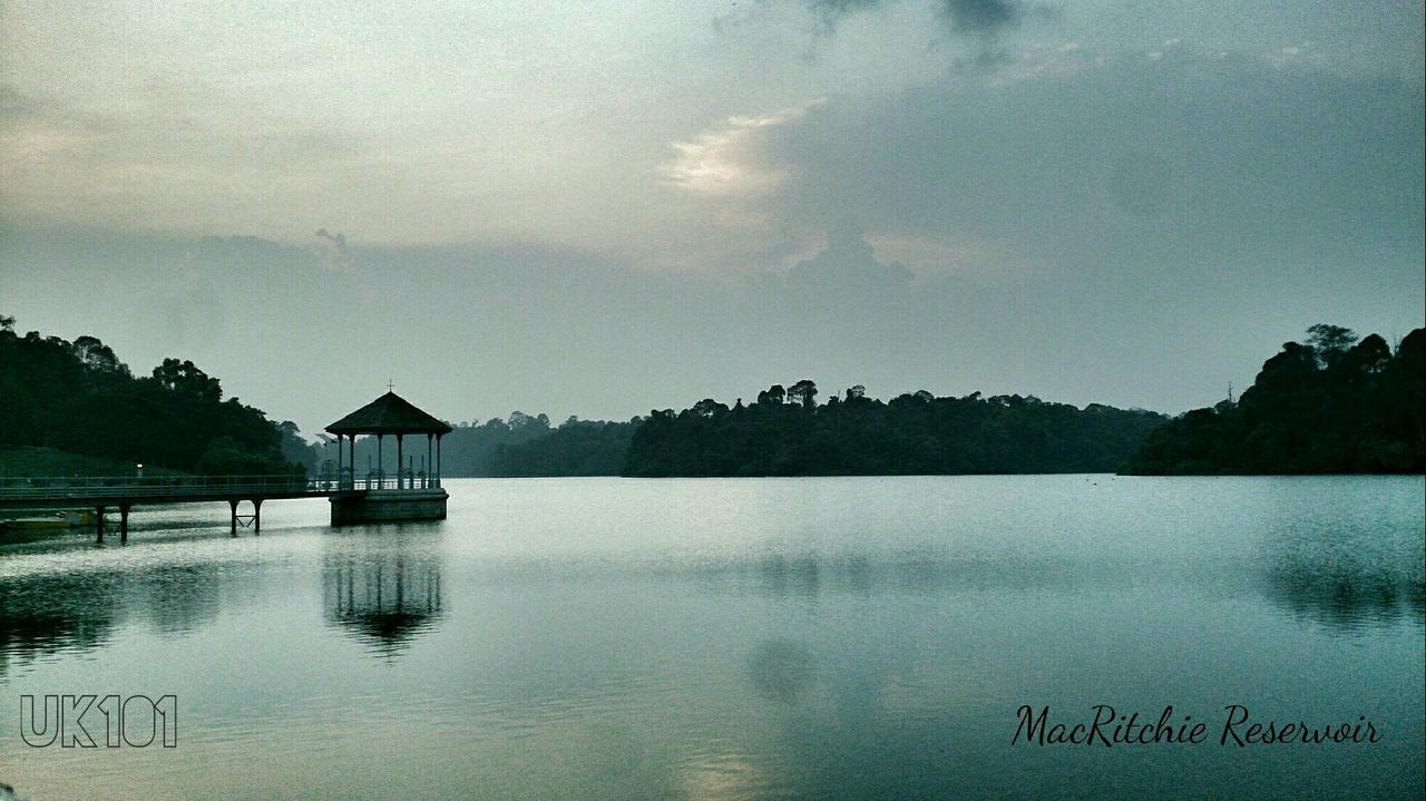 water, lake, tranquil scene, reflection, tranquility, sky, scenics, waterfront, built structure, beauty in nature, nature, architecture, tree, idyllic, cloud - sky, calm, cloud, building exterior, outdoors, mid distance