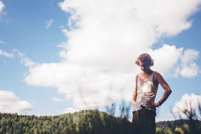 Man standing on field against cloudy sky