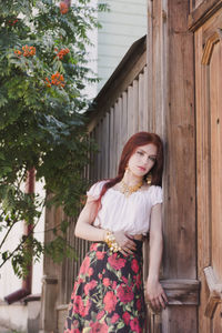 Portrait of woman standing against building