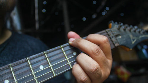 Cropped hand of man playing guitar