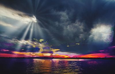 Rainbow over sea against sky during sunset