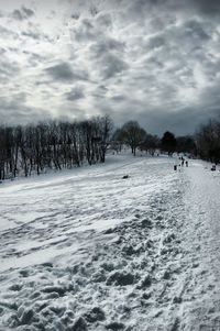 Scenic view of snow covered landscape against cloudy sky