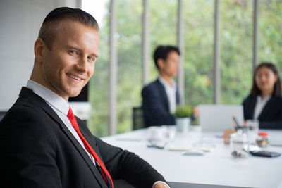 Portrait of man and woman using smart phone at table