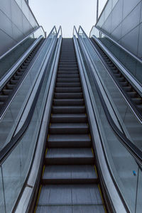 Low angle view of escalator against sky