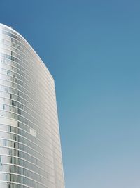 Low angle view of modern building against clear blue sky