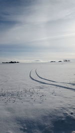 Scenic view of snow covered land against sky