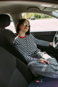 Young woman sitting in car