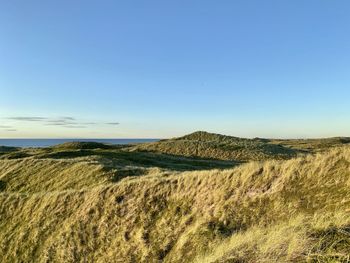 Scenic view of land against clear blue sky