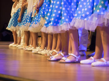 Low section of performers in blue skirt on stage