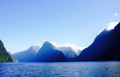 Scenic view of milford sound by mountains against sky