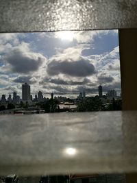 View of cityscape against cloudy sky