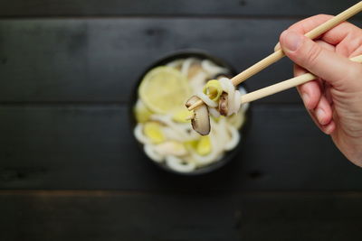 Top down eating asian food udon noodles soup with chopsticks