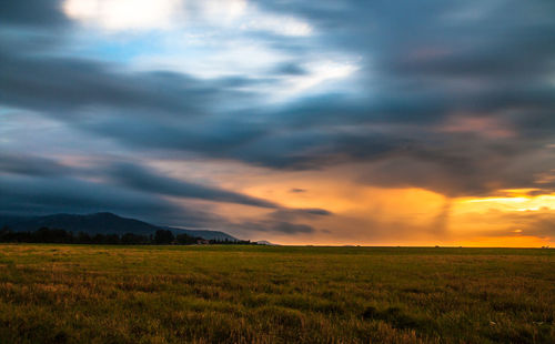 Scenic view of dramatic sky over field