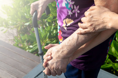 Midsection of man holding hands while standing outdoors