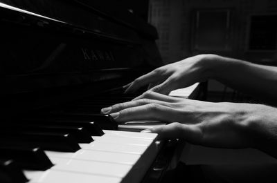 Cropped hands playing piano