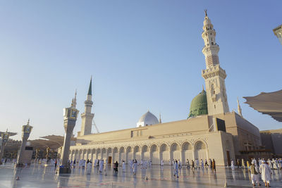 Pilgrims at al-masjid an-nabawi against sky