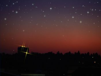 Illuminated city against sky at night