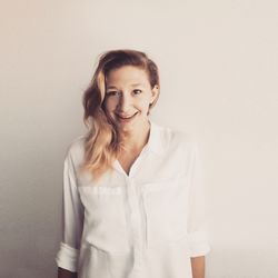 Portrait of smiling young woman against white background