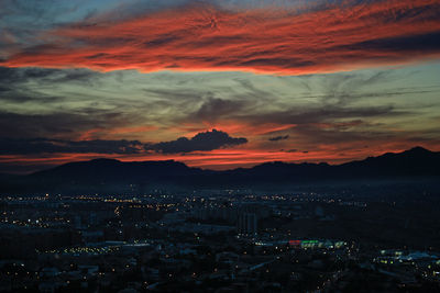 Aerial view of illuminated city at sunset
