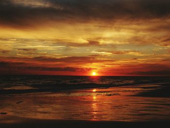 Scenic view of sea against dramatic sky during sunset