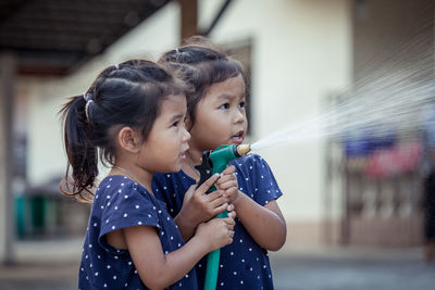 Siblings spraying water