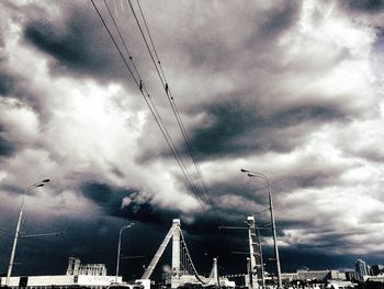 Low angle view of crane against cloudy sky