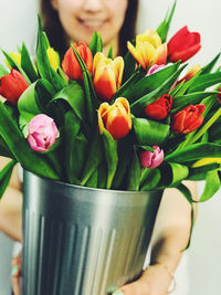 Close-up of hand holding bouquet of red tulip